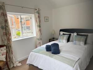 - une chambre avec un grand lit blanc et une fenêtre dans l'établissement Mews house in the centre of Henley-on-Thames, à Henley-on-Thames