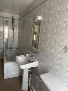 Llangristiolus的住宿－Holland arms hotel，浴室配有盥洗盆和浴缸。