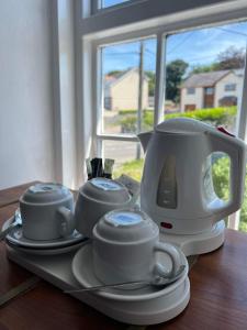 - Hervidor de té y tazas en una bandeja sobre una mesa en Holland arms hotel, en Llangristiolus