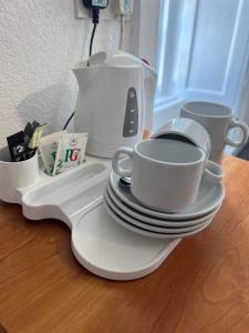 Holland arms hotel في Llangristiolus: طاولة مع أطباق وأكواب وآلة صنع القهوة