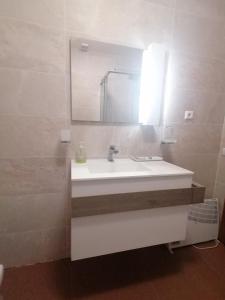 a bathroom with a white sink and a mirror at LÍRIOS DA GRANJA - CASA DE CAMPO in Granja