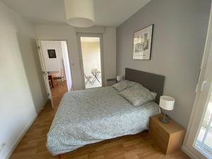 a bedroom with a bed and a table in it at Appart T2 quartier santé et Agro in Rennes