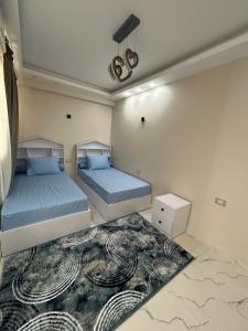 a bedroom with two beds and a rug at Apartment Hossam 1 in Hurghada