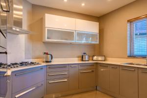 a kitchen with white cabinets and a stove top oven at Beachfront Luxurious Stunning Sunset Boulevard Apartment, Grand Baie in Grand Baie