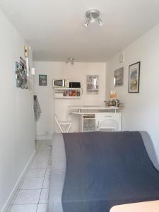 Cette petite chambre comprend un lit et une cuisine. dans l'établissement Le Petit Chalet -Appartement proche de la vieille ville , du centre ville et du Tram- PETIT DEJEUNER OFFERT, au Mans