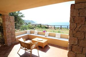 un patio con sofá, mesa y sillas en Residence La Cala infinityholidays, en Costa Paradiso