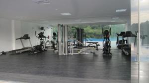 a gym with treadmills and machines in a room at Residencial Paradisus in San José