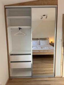 a glass closet with a bed in a bedroom at Apartmán Plešivec ALL4FUN u sjezdovky in Abertamy