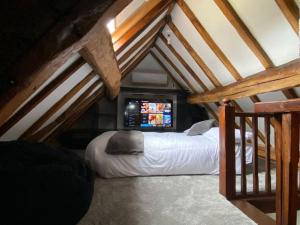 a bedroom with a bed in a attic at The Coach House by Phoenix Premises - Hot Tub Fire Pit BBQ Log Burner Bar Games Room in Birmingham