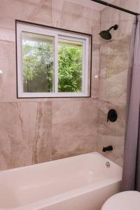 een badkamer met een bad en een raam bij Charming and Stylish Gem in Oak Park