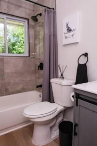 een badkamer met een toilet, een bad en een wastafel bij Charming and Stylish Gem in Oak Park