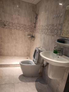 La salle de bains est pourvue de toilettes et d'un lavabo. dans l'établissement Kayan apartment, à Ghubrah