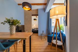 a dining room with blue walls and a table and chairs at Le bleu Jean Denim Arènes - Une Nuit à Nîmes in Nîmes