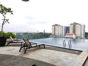 two chairs and a swimming pool on top of a building at AZFA Suites at De Centrum Putrajaya Bangi FREE wifi in Kampong Sungai Kembong Hilir +82 photos
