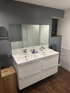 a bathroom with two sinks and a large mirror at The Coach House by Phoenix Premises - Hot Tub Fire Pit BBQ Log Burner Bar Games Room in Birmingham