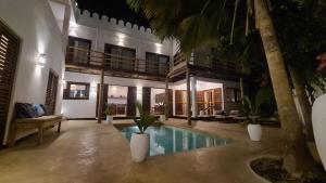 uma villa com uma piscina e uma casa em Kholle Villa em Jambiani