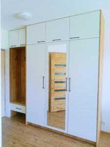 duża biała szafka z drzwiami w pokoju w obiekcie Bounty w Busku Zdroju