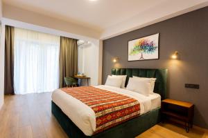 ein Schlafzimmer mit einem großen Bett in einem Zimmer in der Unterkunft Hotel Flower in Tbilisi City