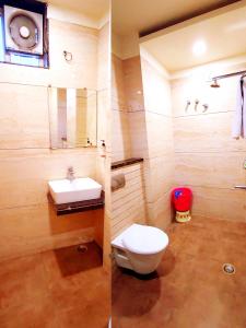 two pictures of a bathroom with a toilet and a sink at Hotel Raj Residency in Bhopal