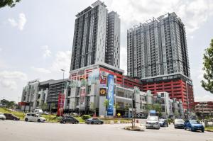 dwa wysokie budynki z samochodami zaparkowanymi na parkingu w obiekcie AZFA Suites at De Centrum Putrajaya Bangi FREE wifi w mieście Kampong Sungai Kembong Hilir