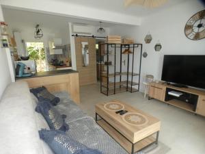 ein Wohnzimmer mit Sofa und Tisch in der Unterkunft Studio avec jardin proche plage Six Fours/Sanary in Six-Fours-les-Plages