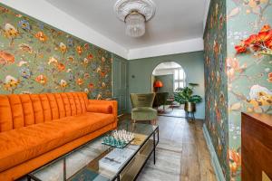 a living room with an orange couch and a table at Insta-worthy Loft on Historic Chester Rows, Sleeps 4 & Free Parking in Chester