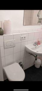 y baño con aseo blanco y lavamanos. en Kölner Apartment direkt am Zentrum, en Colonia