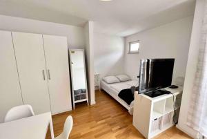 Habitación pequeña con cama y TV. en Kölner Apartment direkt am Zentrum, en Colonia