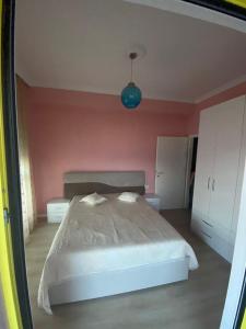 sypialnia z łóżkiem i różową ścianą w obiekcie Hejli's Apartment w Tiranie