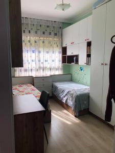 a bedroom with two beds and a desk in it at Hejli's Apartment in Tirana