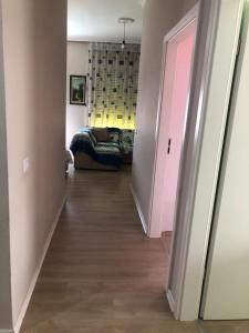 przedpokój z kanapą i różowymi drzwiami w obiekcie Hejli's Apartment w Tiranie