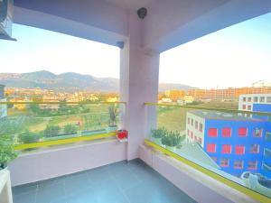 a room with two windows and a view of a city at Hejli's Apartment in Tirana