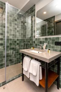 La salle de bains est pourvue d'un lavabo et d'une douche. dans l'établissement Hotel Flower, à Tbilissi