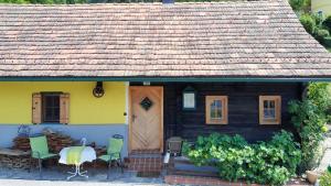 una piccola casa con un tavolo e sedie di fronte di Die Steirakeischn a Großklein