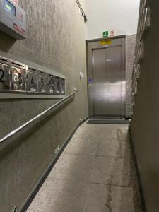 um corredor com uma porta de metal numa estação de metro em Apart Hotel Seg Total Lofts Encantadores em Mogi-Guaçu