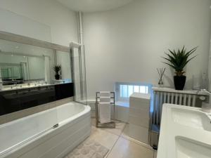 ein Badezimmer mit einer Badewanne, 2 Waschbecken und einer Badewanne in der Unterkunft Grand appartement d'exception au Château Randin in Écully