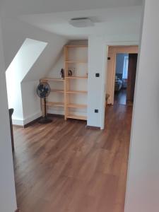 um quarto no sótão com piso em madeira e paredes brancas em Sana em Postojna