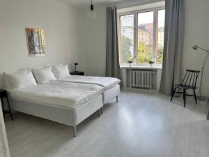 Eteläinen Hesperiankatu في هلسنكي: غرفة نوم بيضاء بها سرير ونافذة