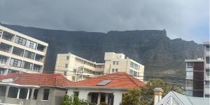 a group of buildings with a mountain in the background at Auberge Gardens in Cape Town