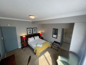 a hotel room with a bed and a chair at Auberge Gardens in Cape Town