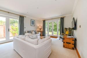 a living room with a white couch and chairs at Woodland Cottage by inspirestays-com in Duneton