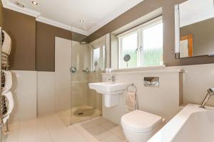 a bathroom with a toilet and a sink and a shower at Woodland Cottage by inspirestays-com in Duneton +34 photos