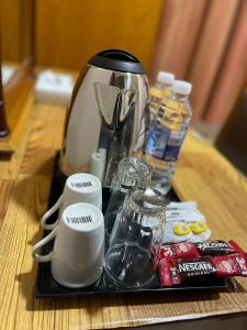 a tray with a coffee maker and cups on a table at Al Ghadeer Hotel Apartment in Sharjah
