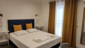 1 dormitorio con 1 cama con cabecero azul y ventana en Elodie's Country House - Alojamento Local en Grândola