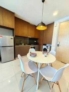uma cozinha com mesa e cadeiras e uma cozinha com frigorífico em A3007 Grand Medini 100mbps Netflix By STAY em Nusajaya