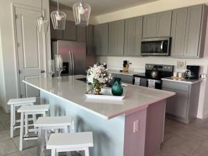 a kitchen with a large island with white counter tops at FREE Amenities with Kids Waterpark in Luxury House in Davenport