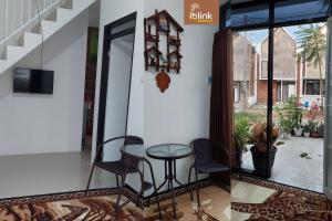 a table and chairs in a room with a staircase at IbLink Homestay Family Homestay di Malang Full AC in Malang