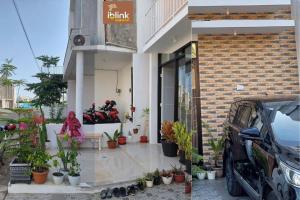 a building with plants and motorcycles parked outside of it at IbLink Homestay Family Homestay di Malang Full AC in Malang