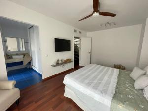 1 dormitorio con 1 cama y TV de pantalla plana en Tokyo Rooms (El Playazo) - Habitación PREMIUM con baño privado en Almería