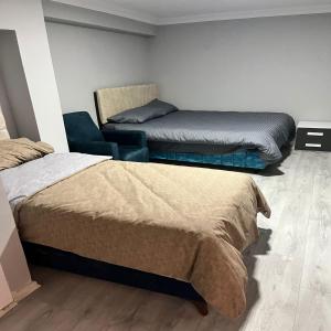 ein Zimmer mit 2 Betten und einem Stuhl darin in der Unterkunft GRAND WHİTE SUİT OTEL in Sivas